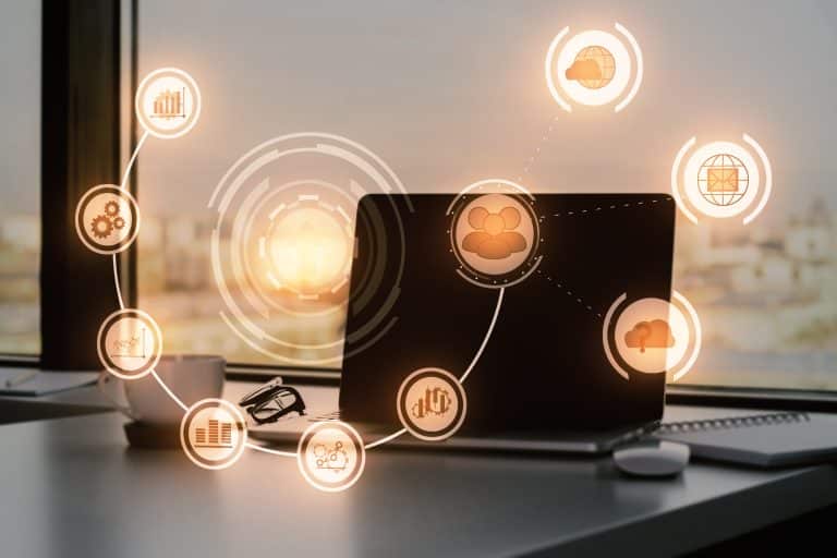 Laptop on an office desk with digital workflow icons representing organised support requests, ticket tracking, automation, and service management processes.